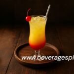 Layered orange mocktail with strawberry syrup and soda in a tall glass, garnished with orange slice and mint.